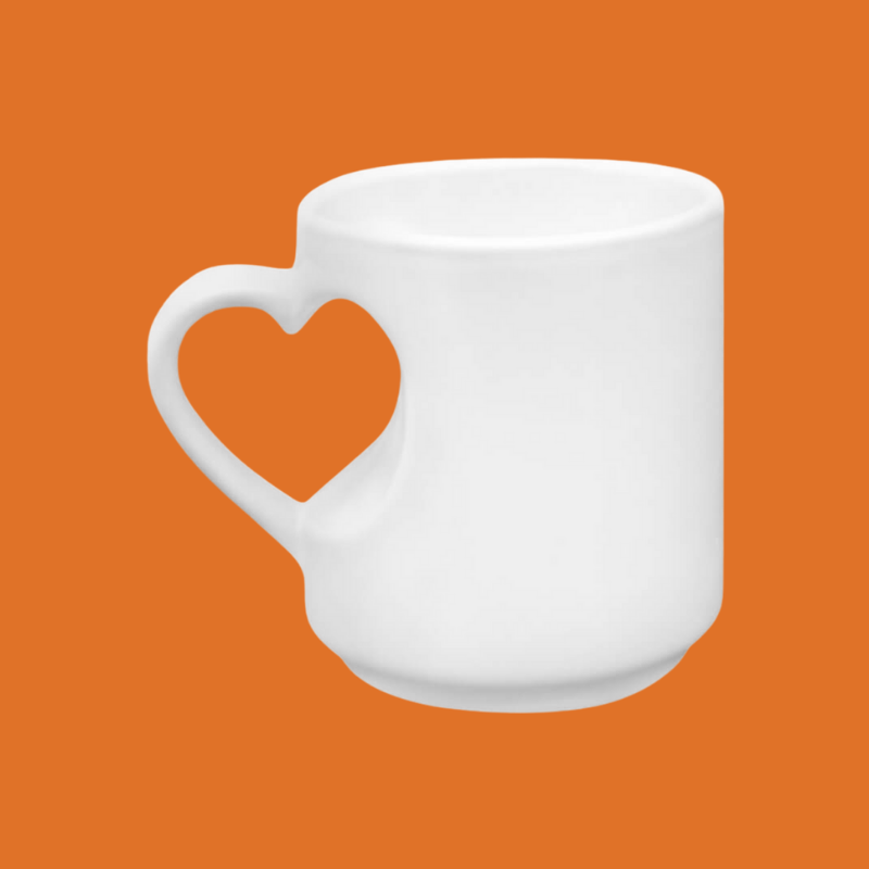 "Taza blanca de porcelana con asa calada en forma de corazón sobre fondo naranja, vista lateral"