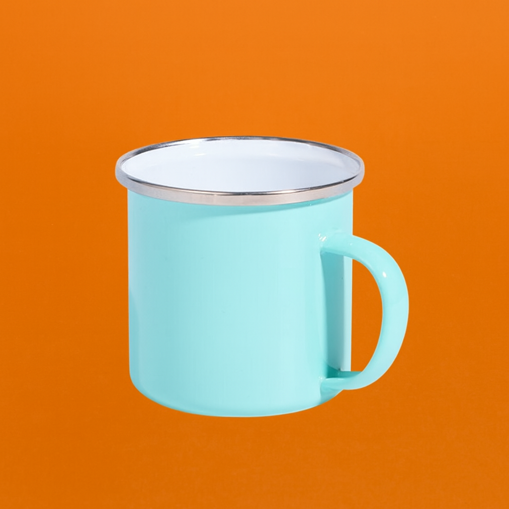 Taza esmaltada color menta con borde metálico sobre fondo naranja, vista lateral</p>
<p>